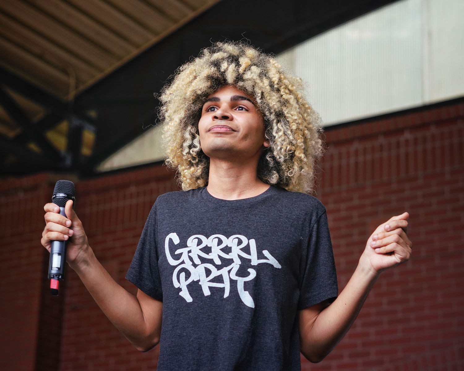 Photo of musician, Sci-Fi, with both hands raised and holding a microphone in one of them.